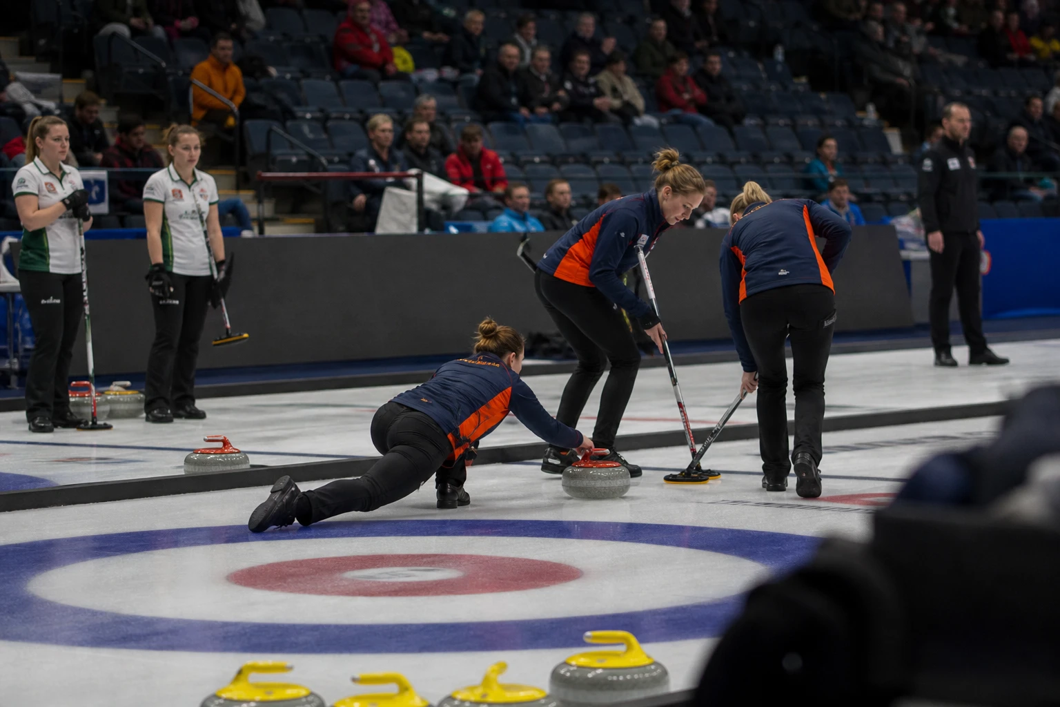 Curlingarena med flera banor bredvid varandra och tomma läktare