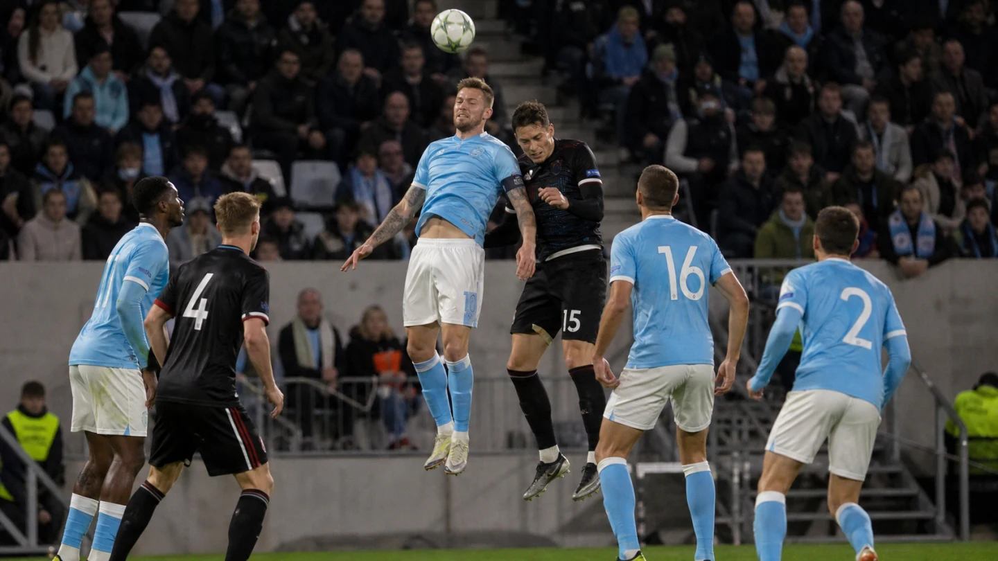 Europeisk klubblagsmatch på en mindre arena i grönt kvällsljus.